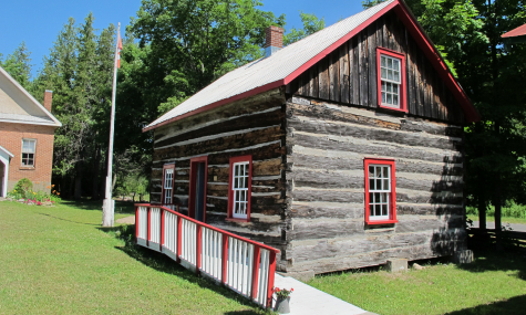 log cabin with red and white windows and porch